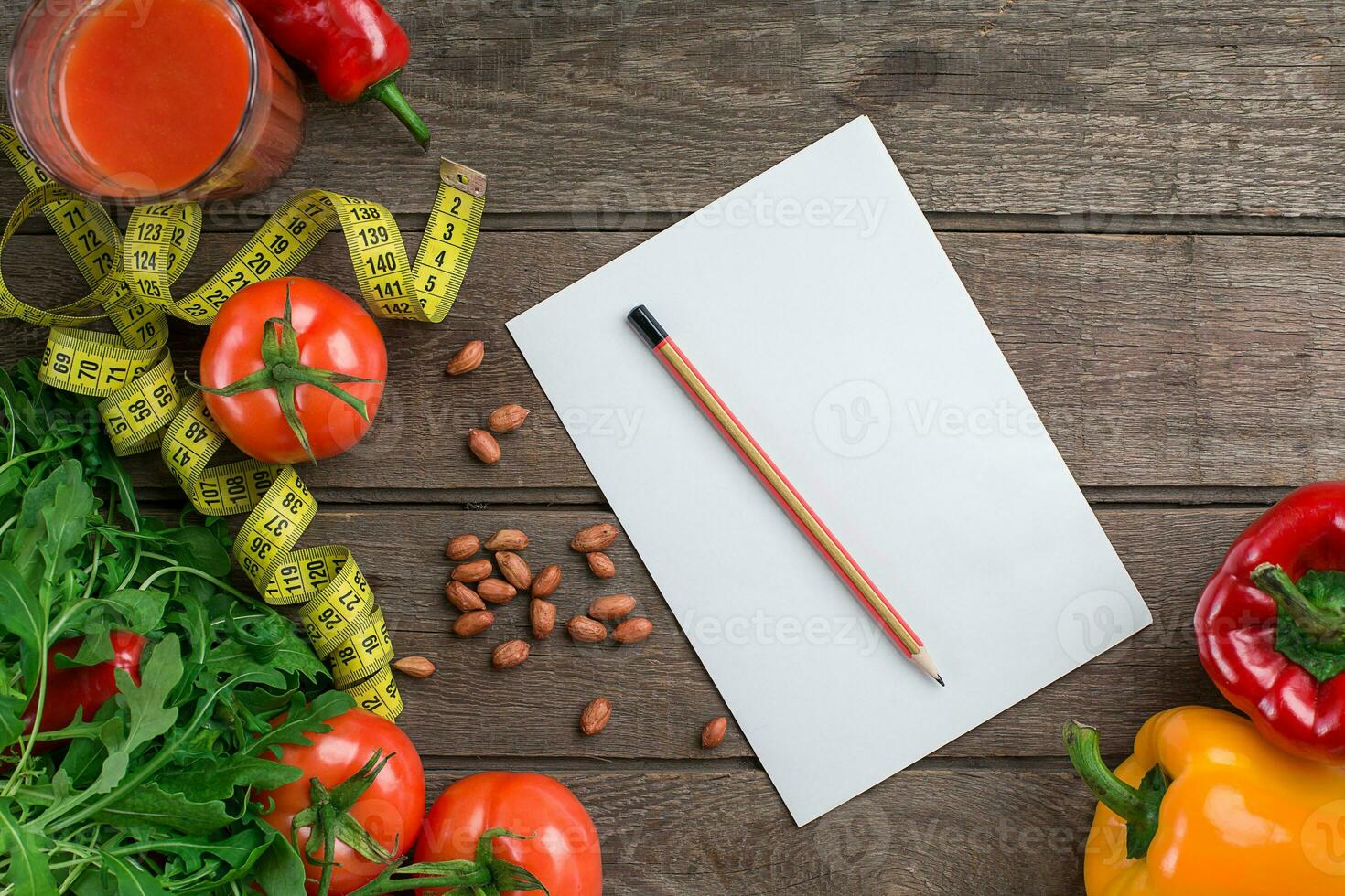 Glass of tomato juice with vegetables and measuring tape on table close-up photo