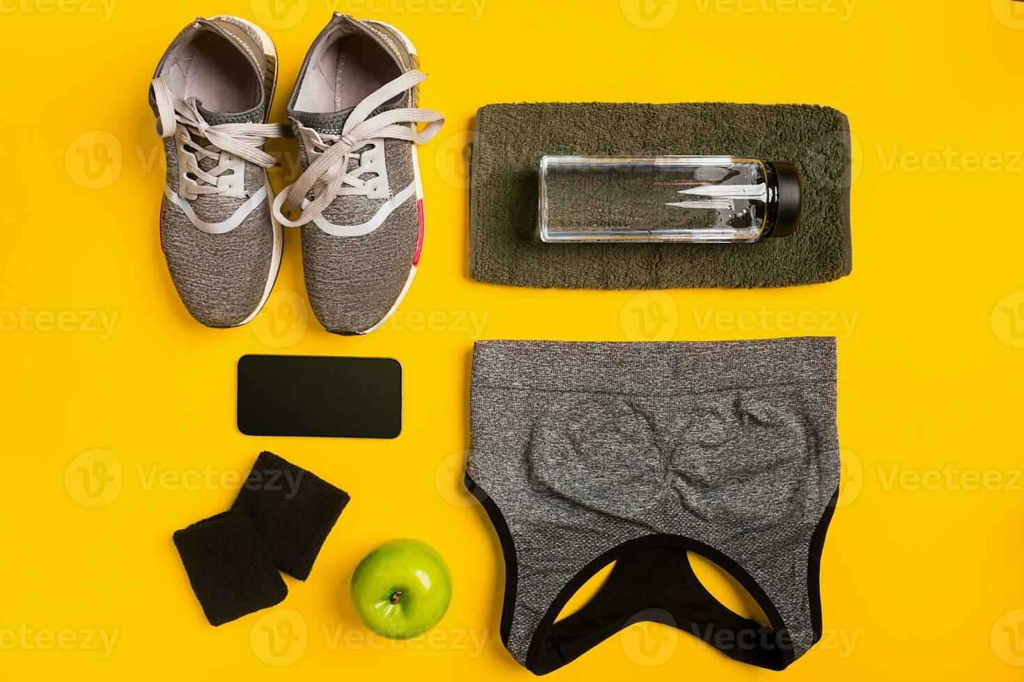 aptitud accesorios en un amarillo antecedentes. zapatillas, botella de agua, elegante, toalla y deporte cima. foto