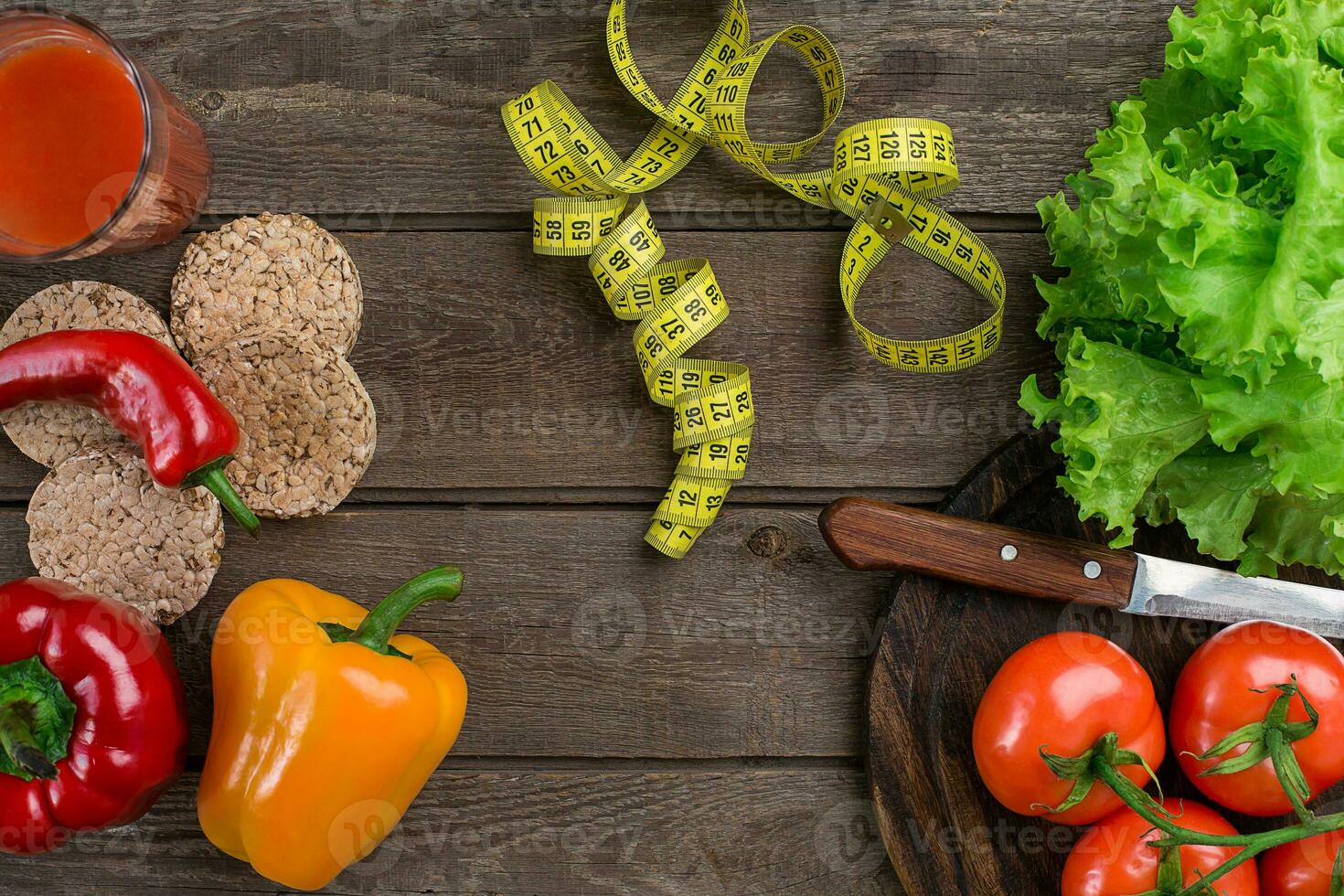 Sport and diet. Vegetables, a glass of tomato juice and centimeter. Peppers, tomatoes, salad on rustic background photo