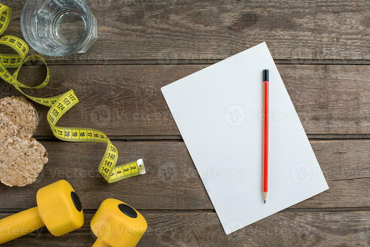 Glass of water with vegetables and measuring tape on table close-up photo