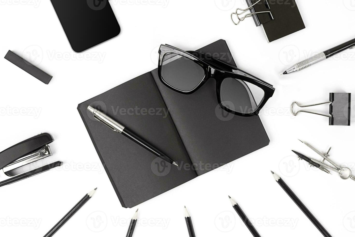 Blank notepad with clips, pens and glasses flat lay. photo