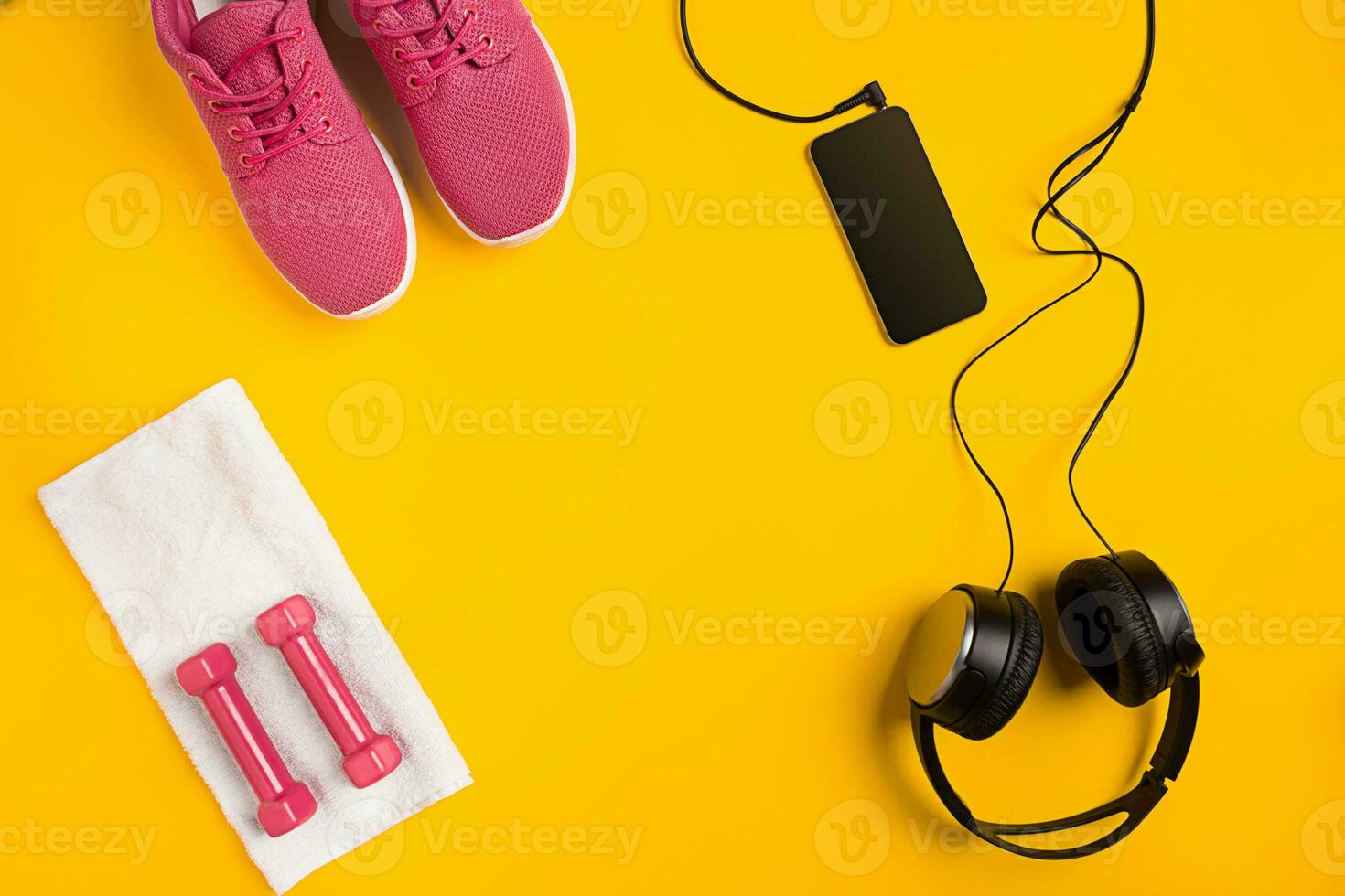 Athlete's set with female clothing, dumbbells and bottle of water on yellow background photo