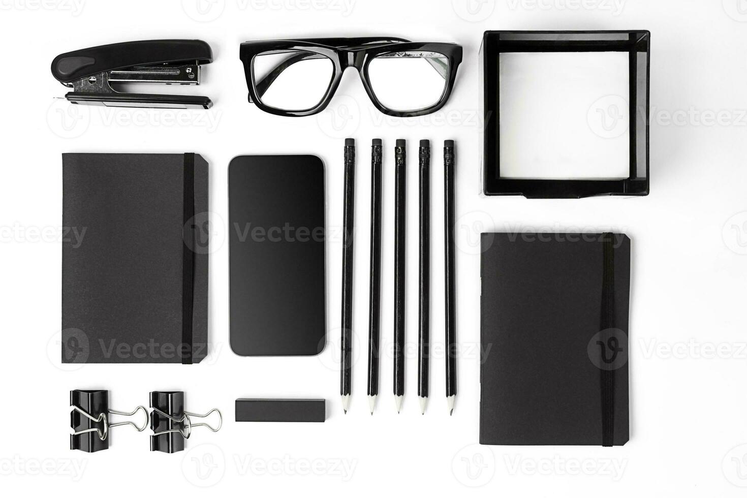 Blank notepad with clips, pens and glasses flat lay. photo