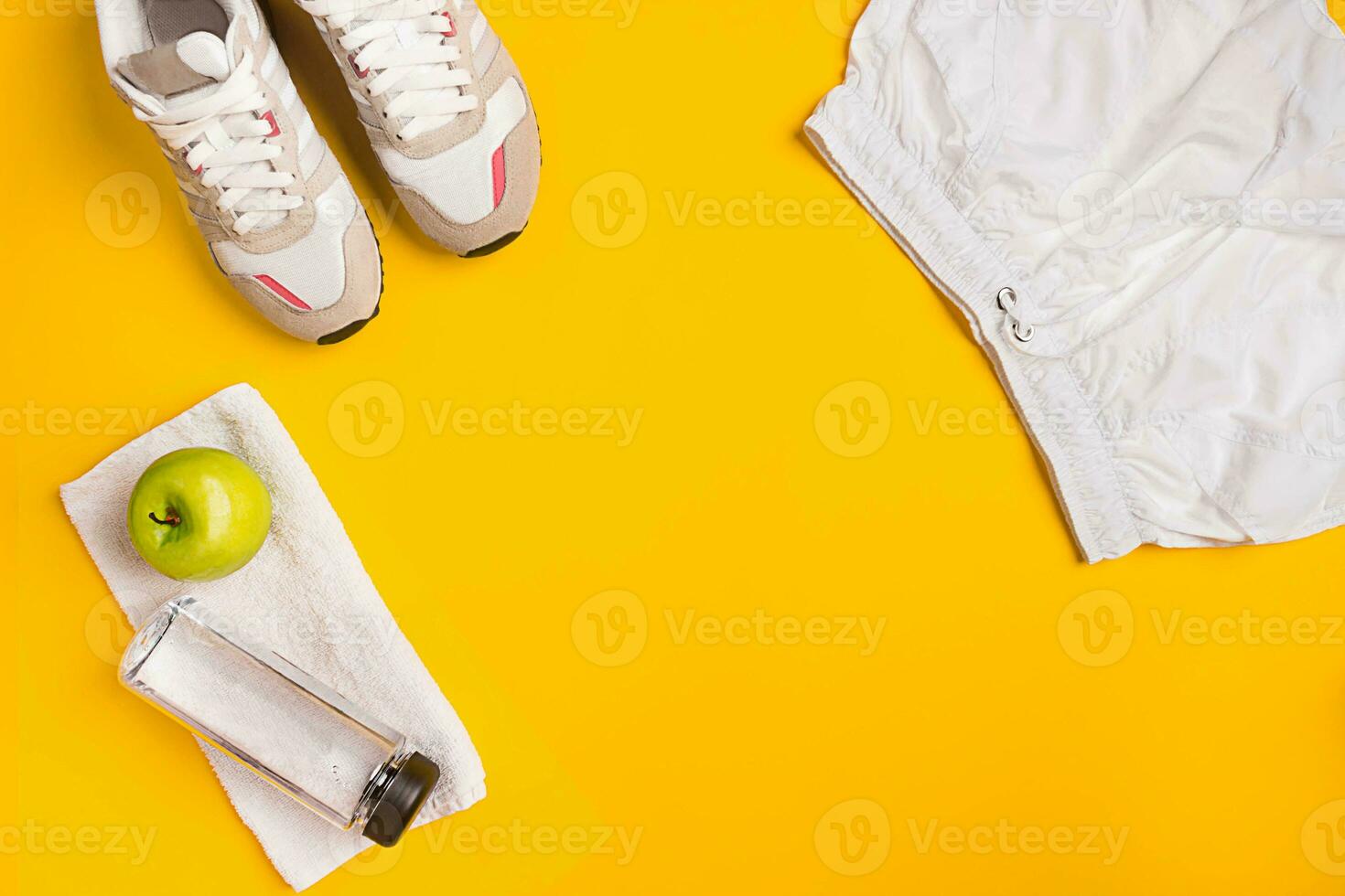 Athlete's set with female clothing and bottle of water on yellow background photo