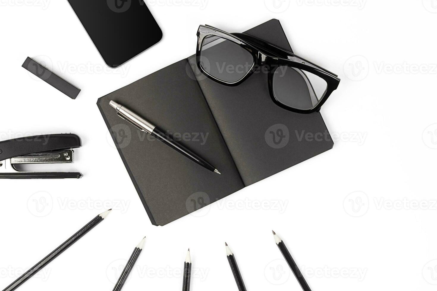 Blank notepad with clips, pens and glasses flat lay. photo