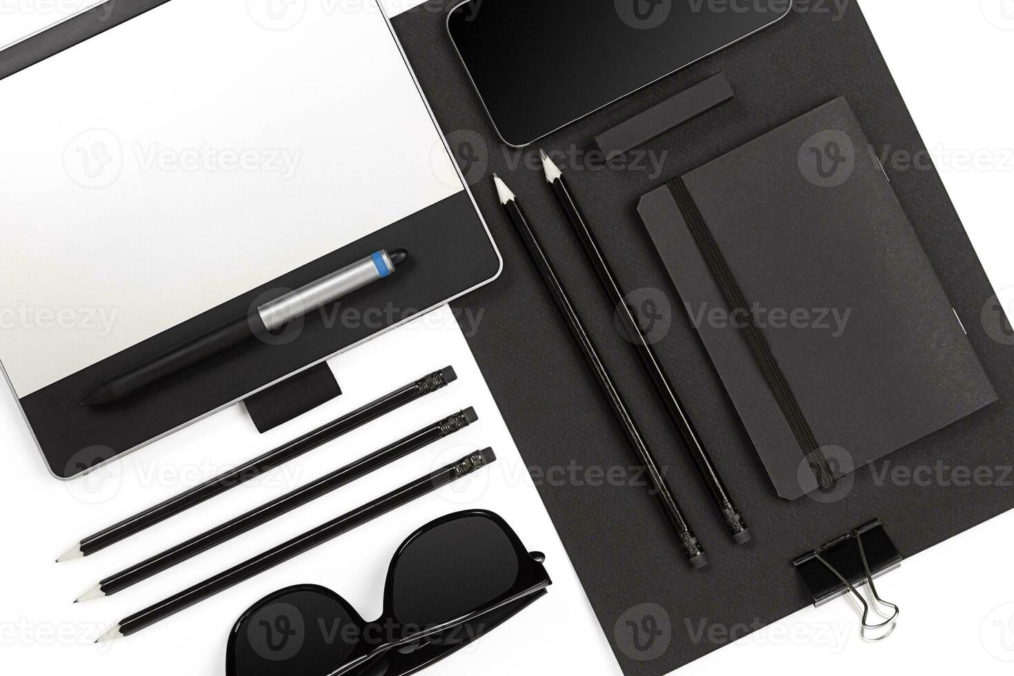 Blank notepad with clips, pens and glasses flat lay. photo