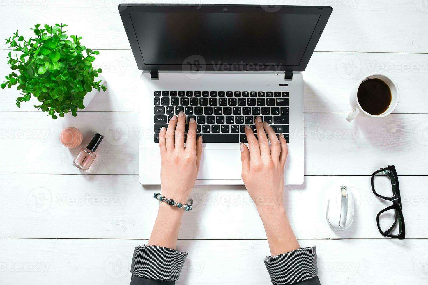 Laptop with blank screen and girl's hands. Flat lay, top view workspace photo