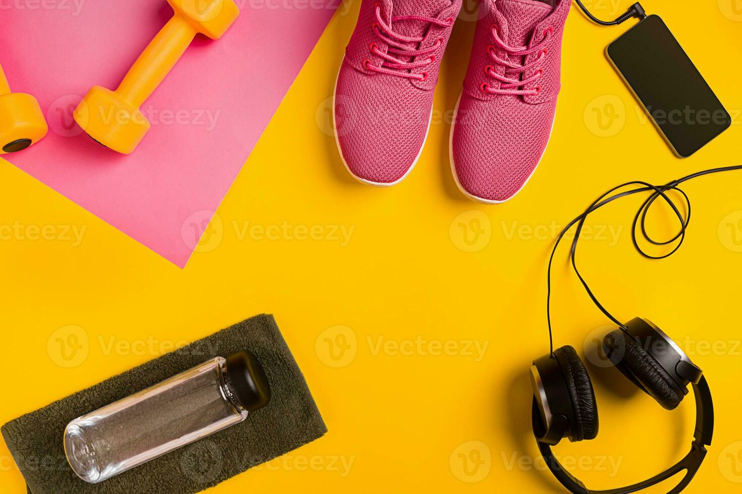 Athlete's set with female clothing, dumbbells and bottle of water on yellow background photo