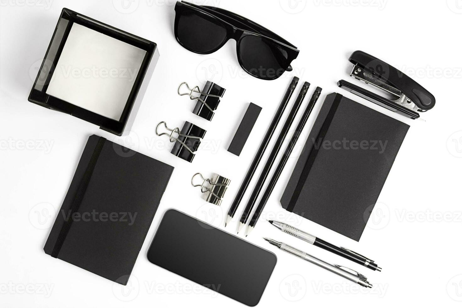 Blank notepad with clips, pens and glasses flat lay. photo