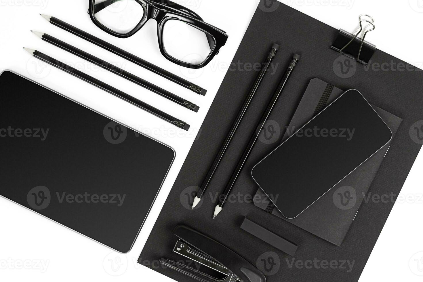 Blank notepad with clips, pens and glasses flat lay. photo