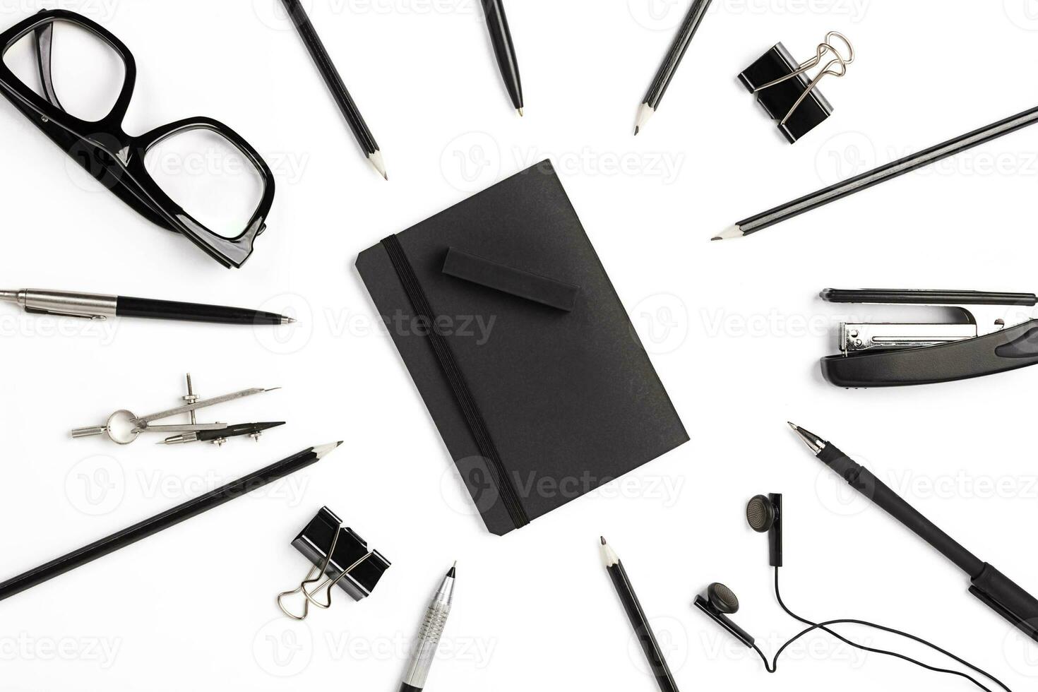 Blank notepad with clips, pens and glasses flat lay. photo