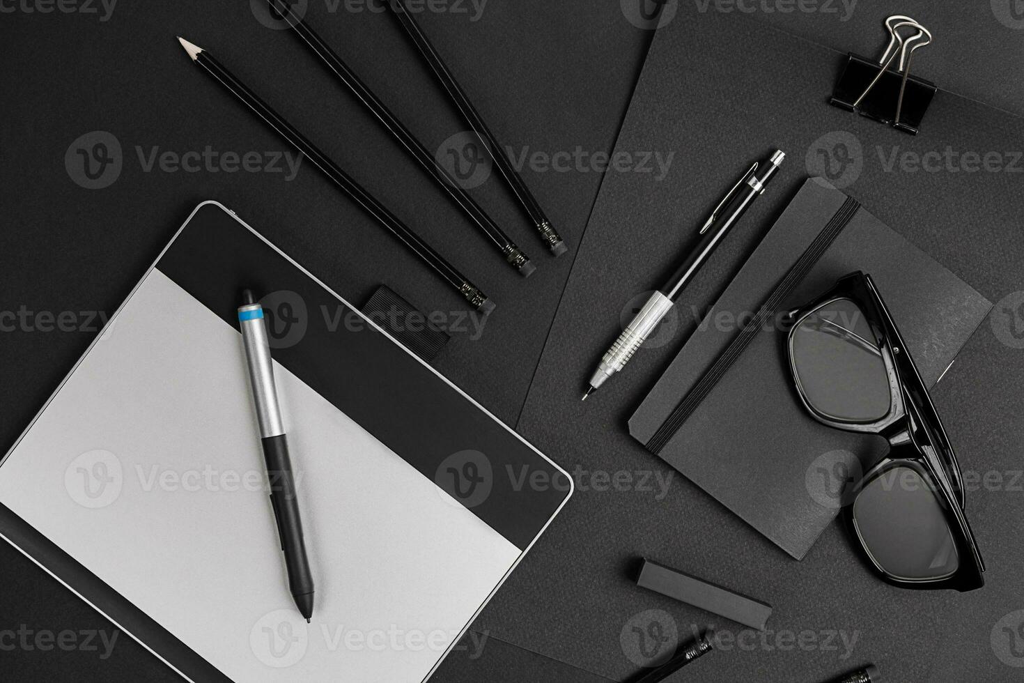 Blank notepad with clips, pens and glasses flat lay. photo