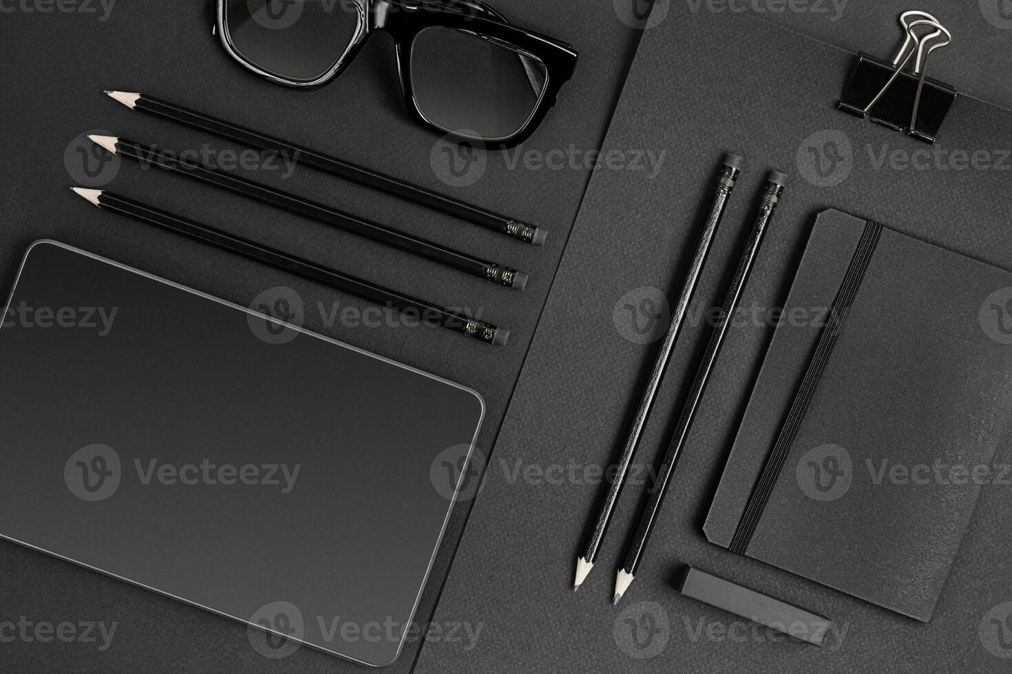 Blank notepad with clips, pens and glasses flat lay. photo