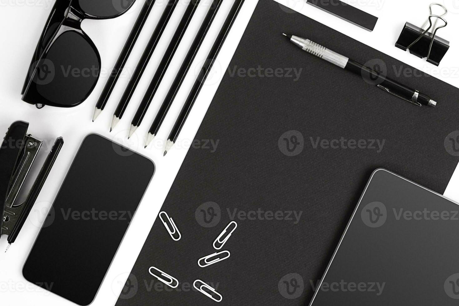 Blank notepad with clips, pens and glasses flat lay. photo