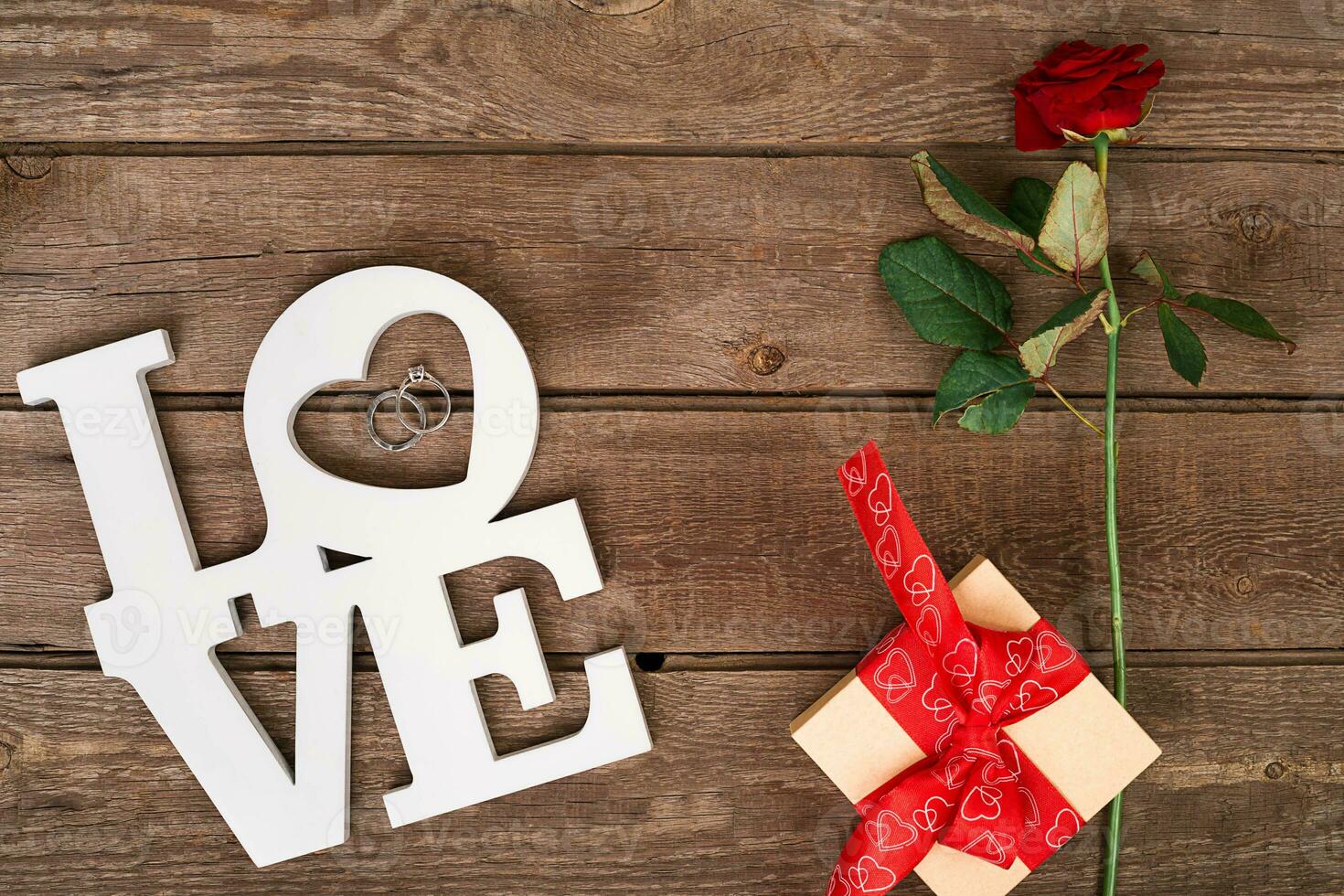 Box with red ribbon and rose on a wooden background, Valentine's Day concept photo
