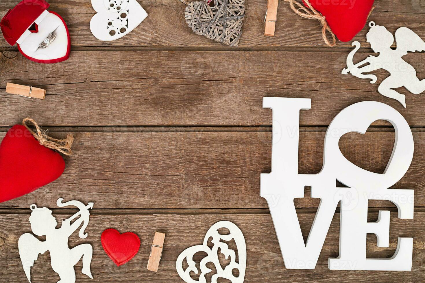 Valentines day ring and handmaded hearts over wooden table. photo