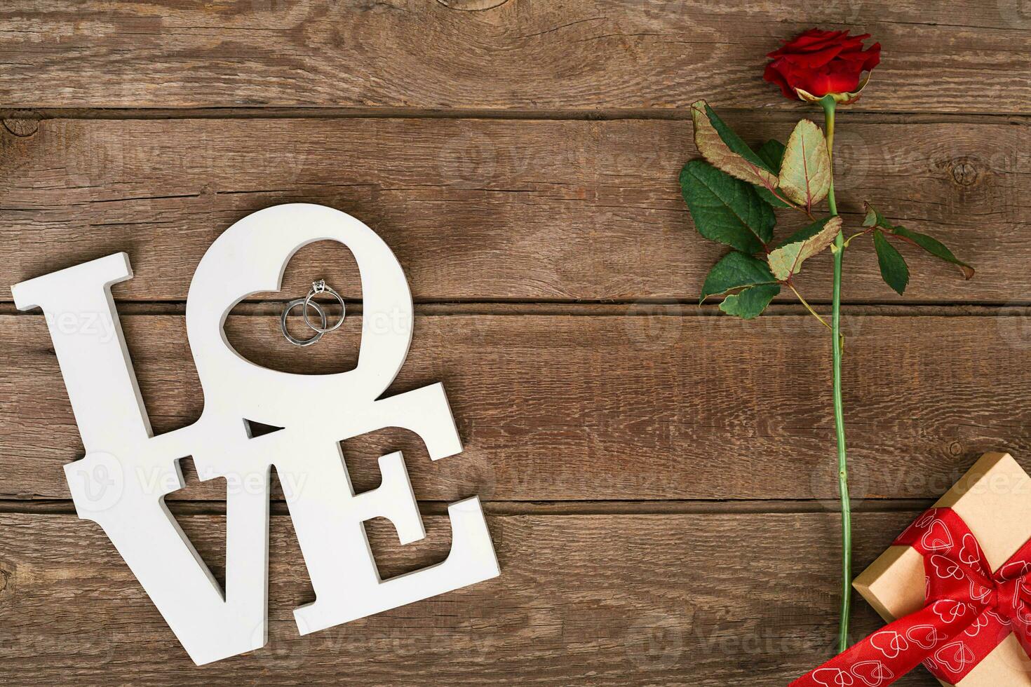 Box with red ribbon and rose on a wooden background, Valentine's Day concept photo