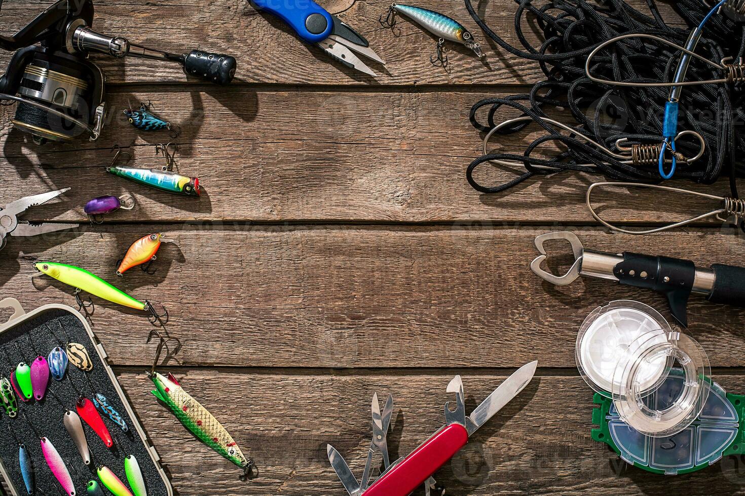 Fishing tackle - fishing spinning, fishing line, hooks and lures on wooden background. photo