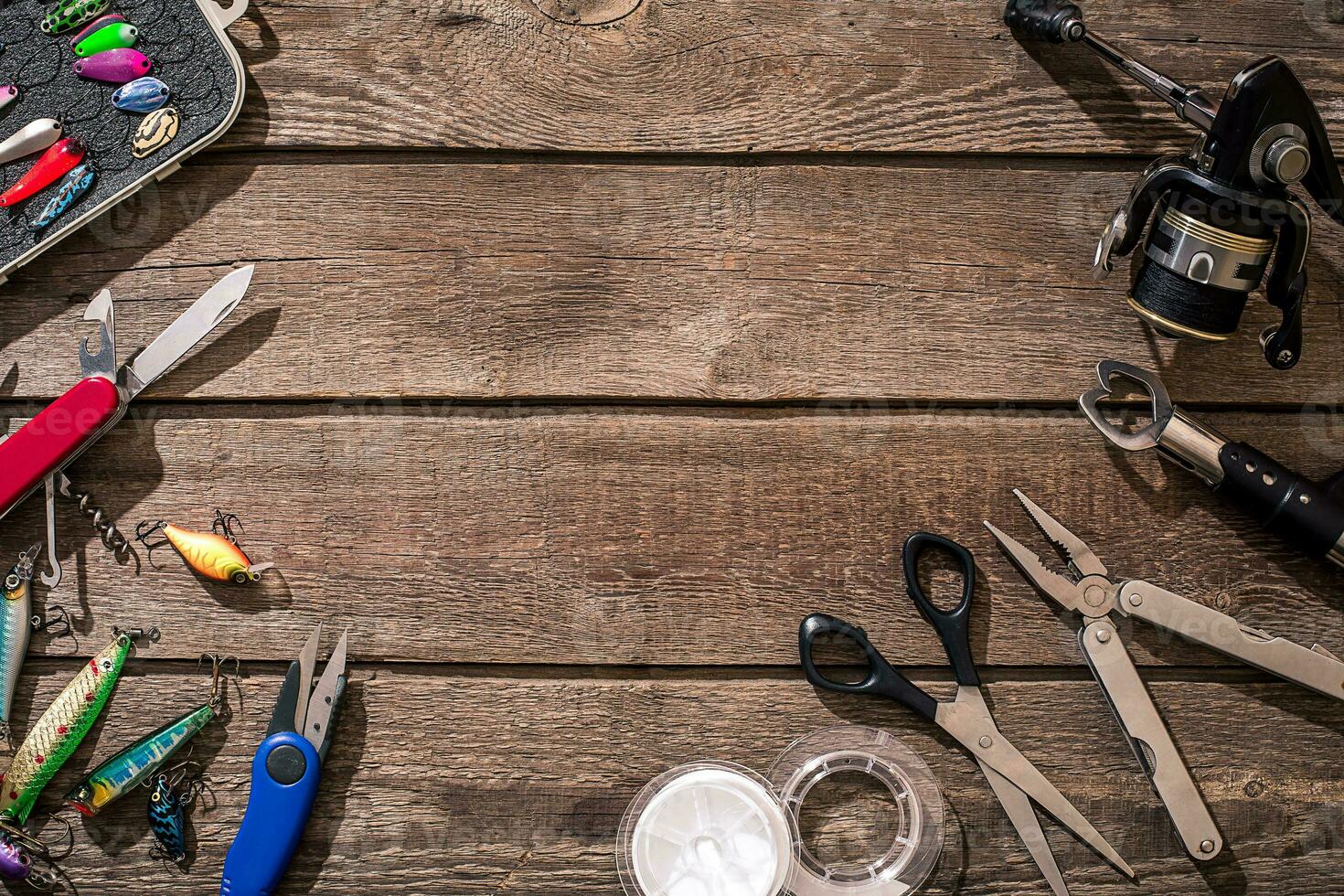 Fishing tackle - fishing spinning, fishing line, hooks and lures on wooden background. photo