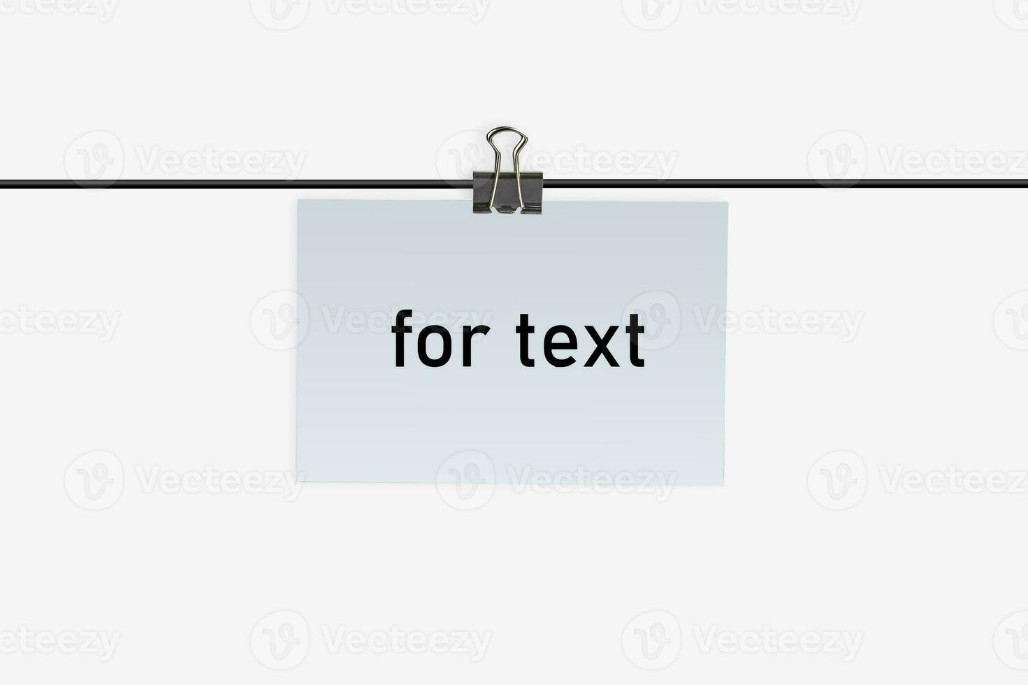 A small piece of paper with inscription for text, clamped by binder clip to a wire and hanging on it. Isolated on white. Close up, copy space photo