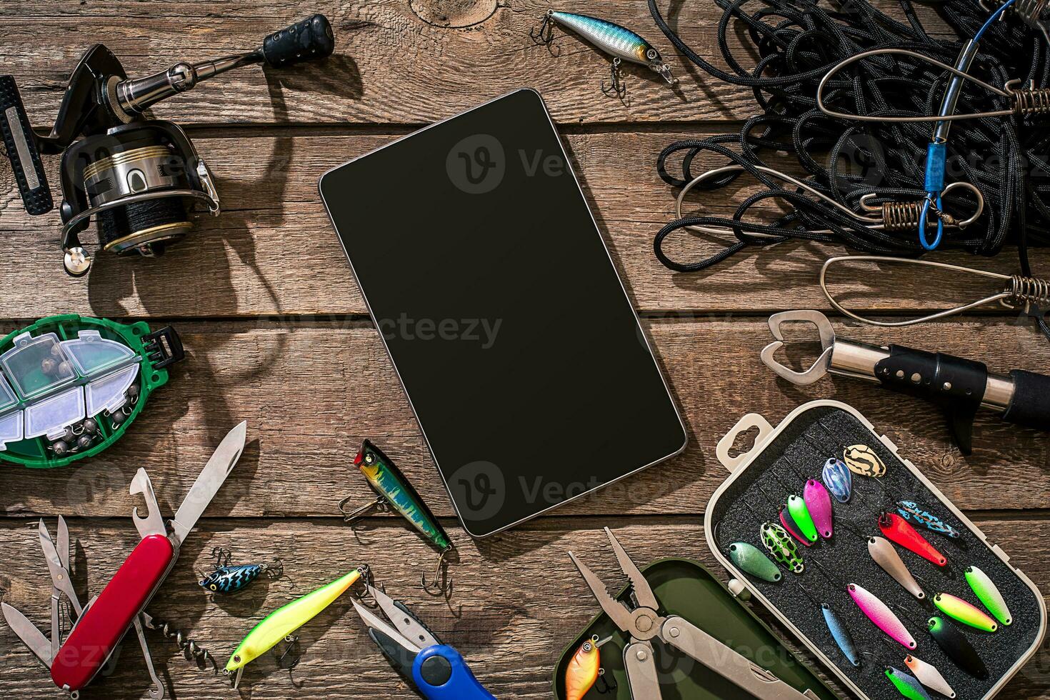 Fishing tackle - fishing spinning, fishing line, hooks and lures on wooden background. photo