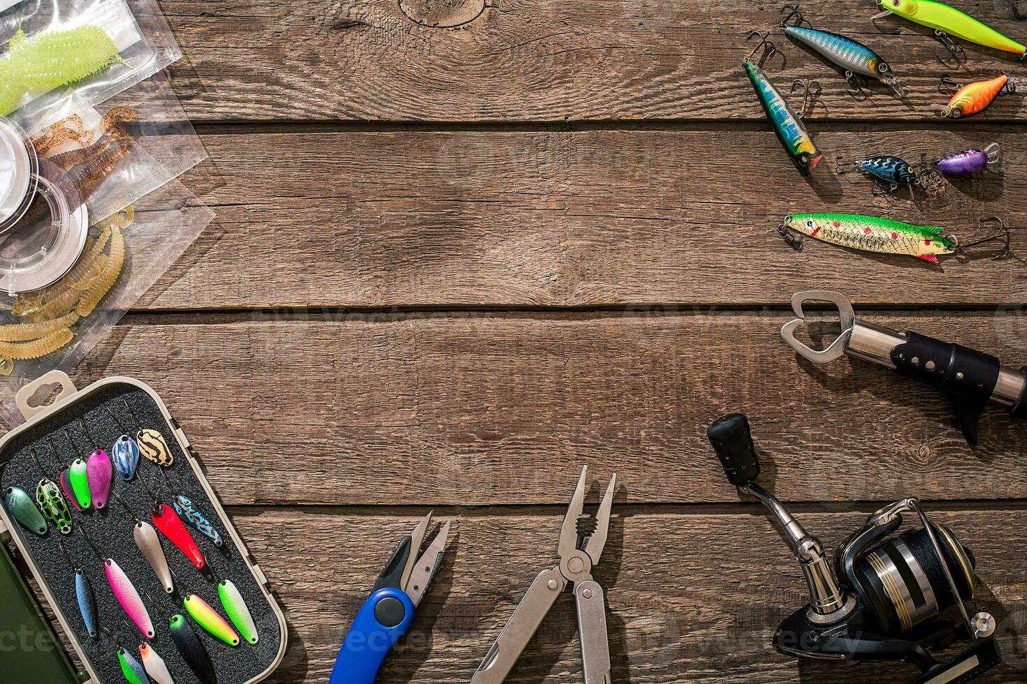 Fishing tackle - fishing spinning, fishing line, hooks and lures on wooden background. photo