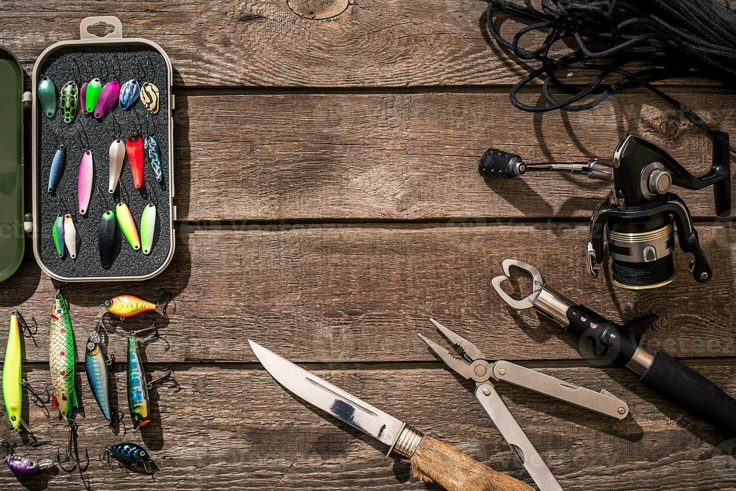 Fishing tackle - fishing spinning, fishing line, hooks and lures on wooden background. photo