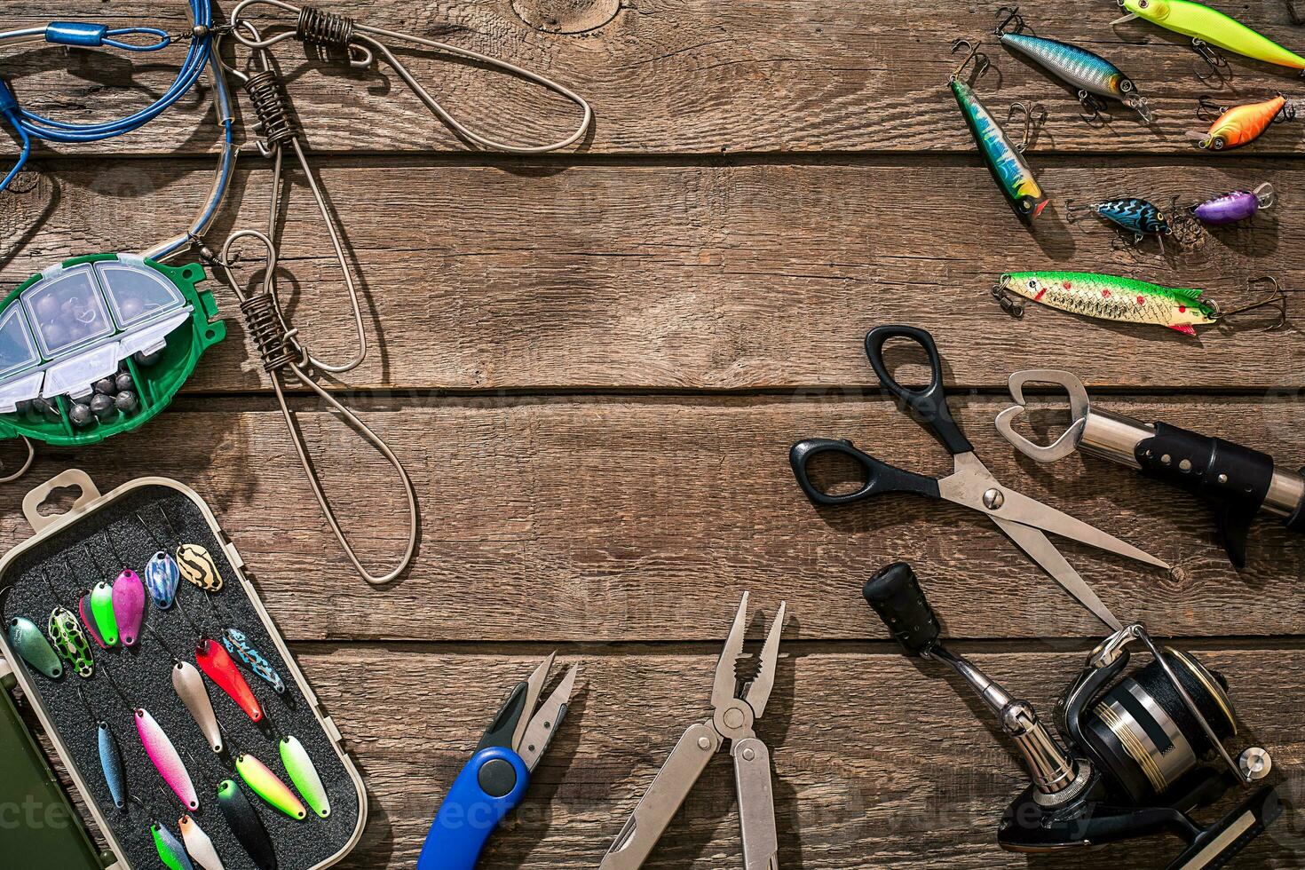 Fishing tackle - fishing spinning, fishing line, hooks and lures on wooden background. photo