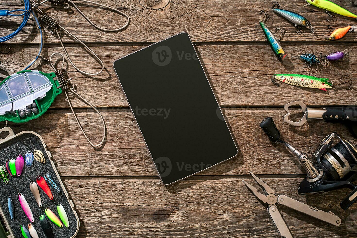 Fishing tackle - fishing spinning, fishing line, hooks and lures on wooden background. photo