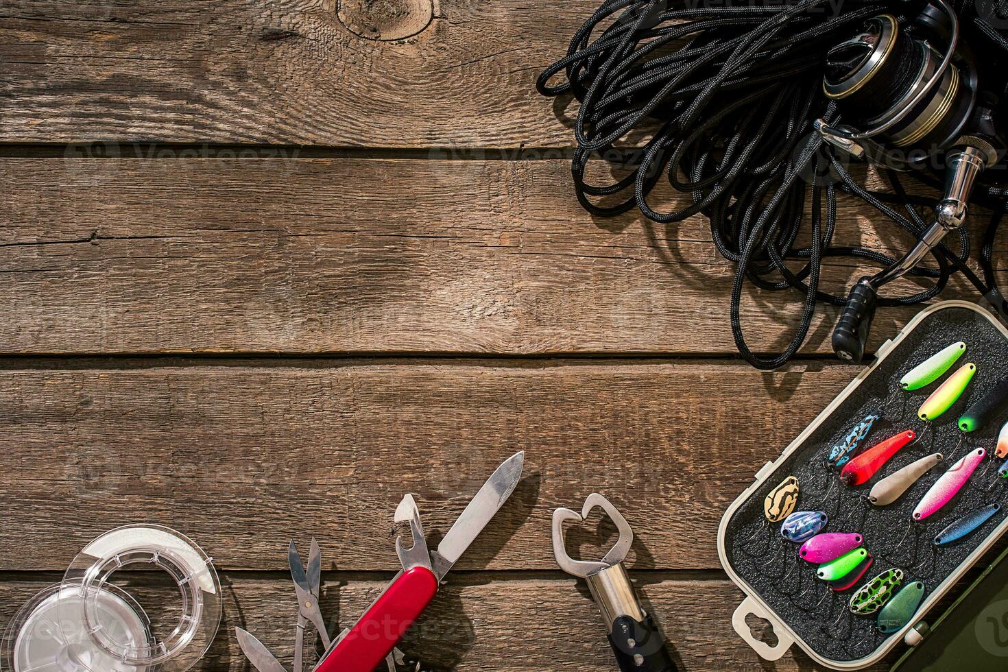 Fishing tackle - fishing spinning, fishing line, hooks and lures on wooden background. photo