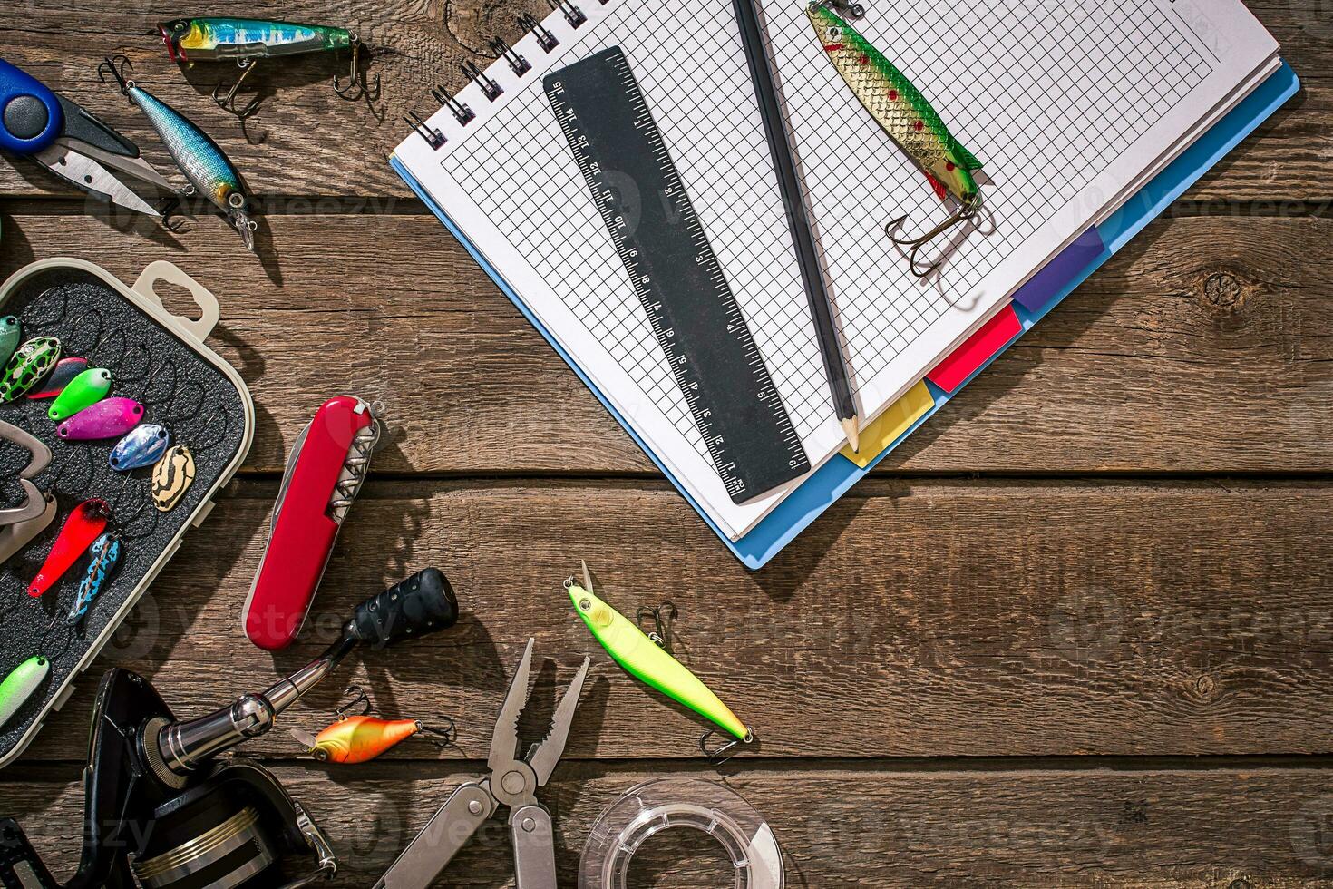 Fishing tackle - fishing spinning, fishing line, hooks and lures on wooden background. photo