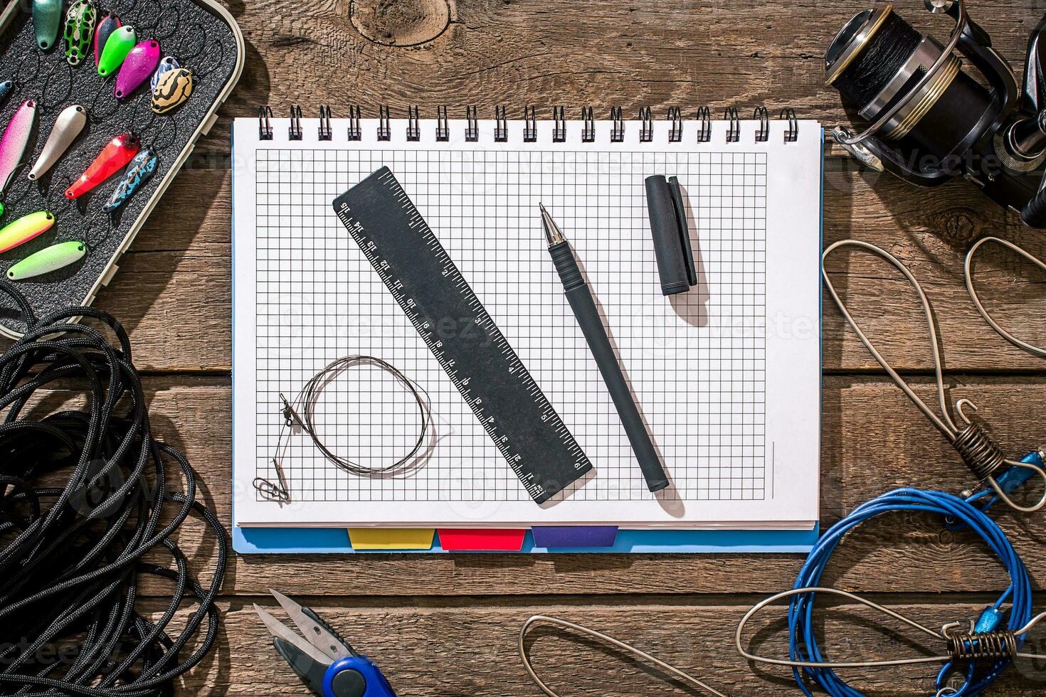 Fishing tackle - fishing spinning, fishing line, hooks and lures on wooden background. photo