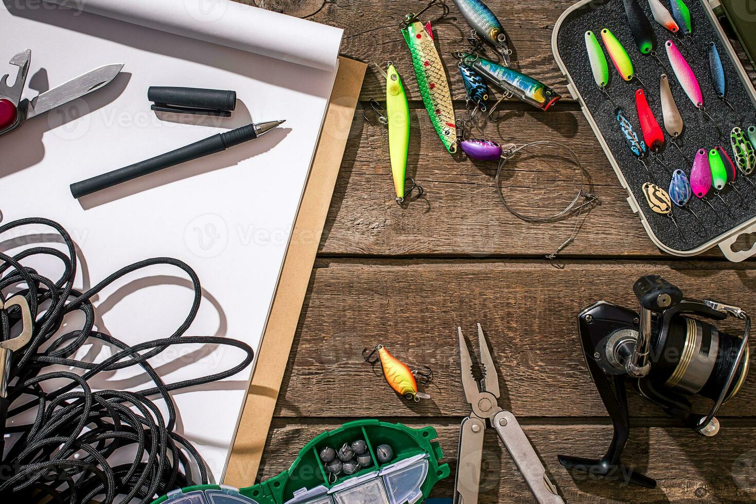 Fishing tackle - fishing spinning, fishing line, hooks and lures on wooden background. photo