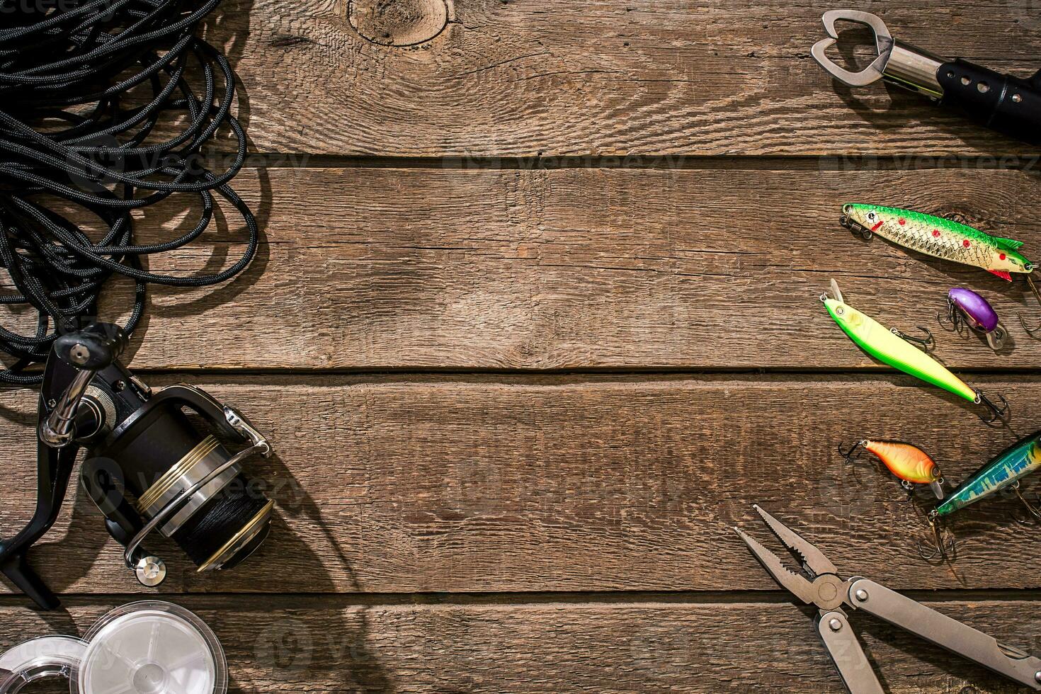 Fishing tackle - fishing spinning, fishing line, hooks and lures on wooden background. photo