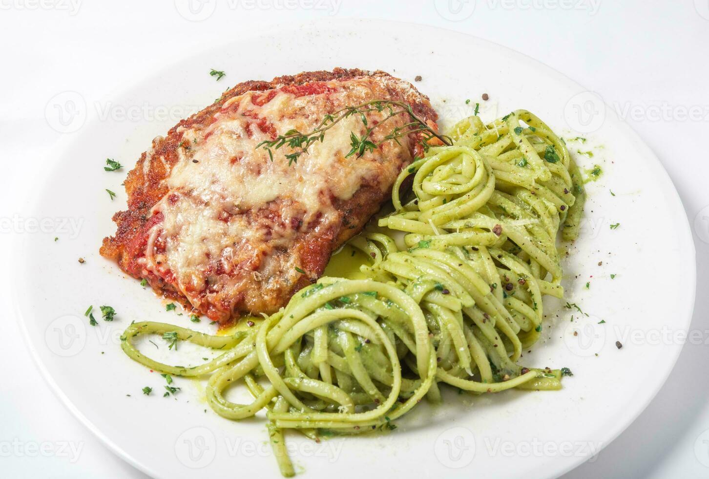 Chicken with parmesan cheese and linguine pasta in pesto sauce photo