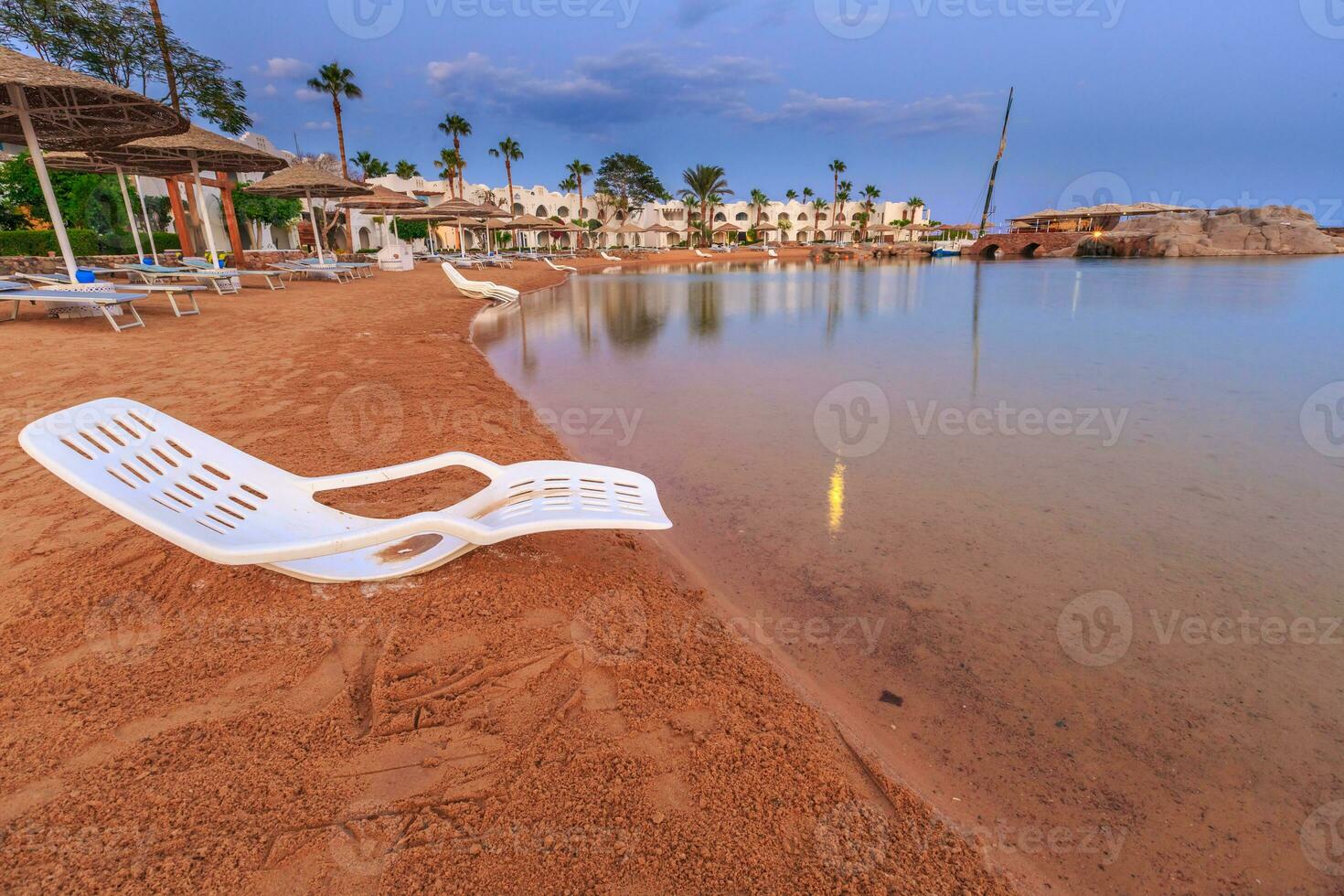 Landscape of lonely beachchair near sea and beautiful sunset. photo