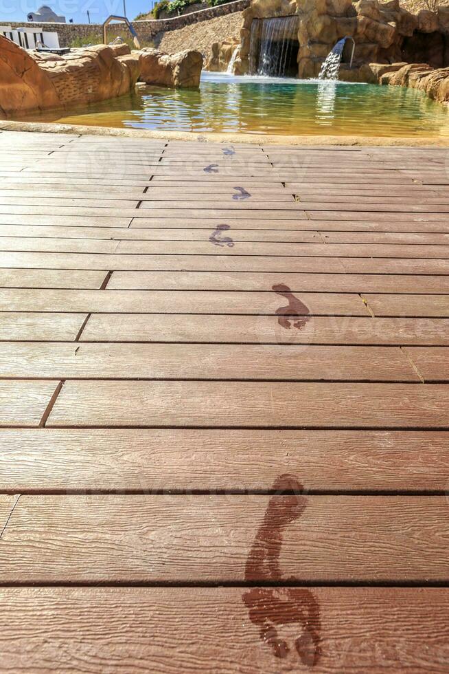 Closeup footprints on the wooden floor behind it swimming pool photo