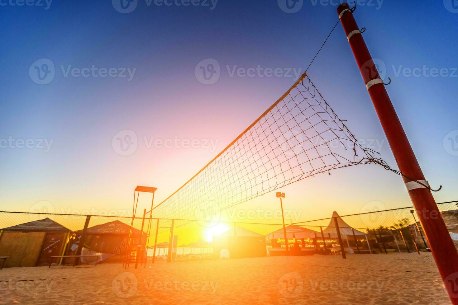 Sillhouette of a volleyball net and sunrise on the beach photo