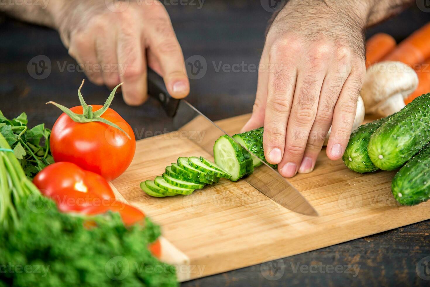 Male hands cutting vegetables for salad photo