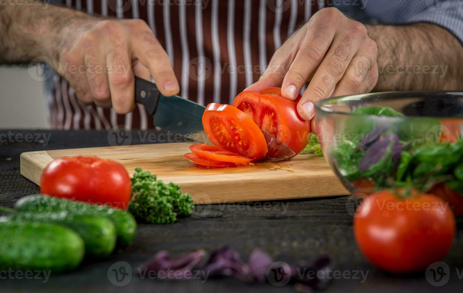 Male hands cutting vegetables for salad photo