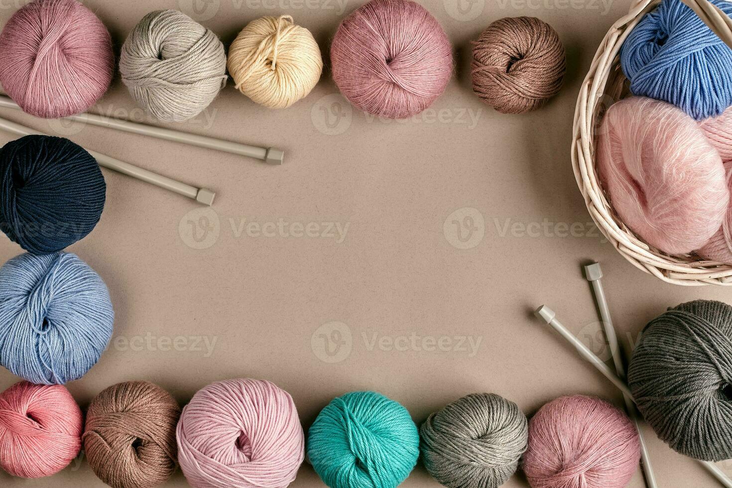 Set of colorful wool yarn on beige background. Top view. Frame of tangles of knitting threads photo