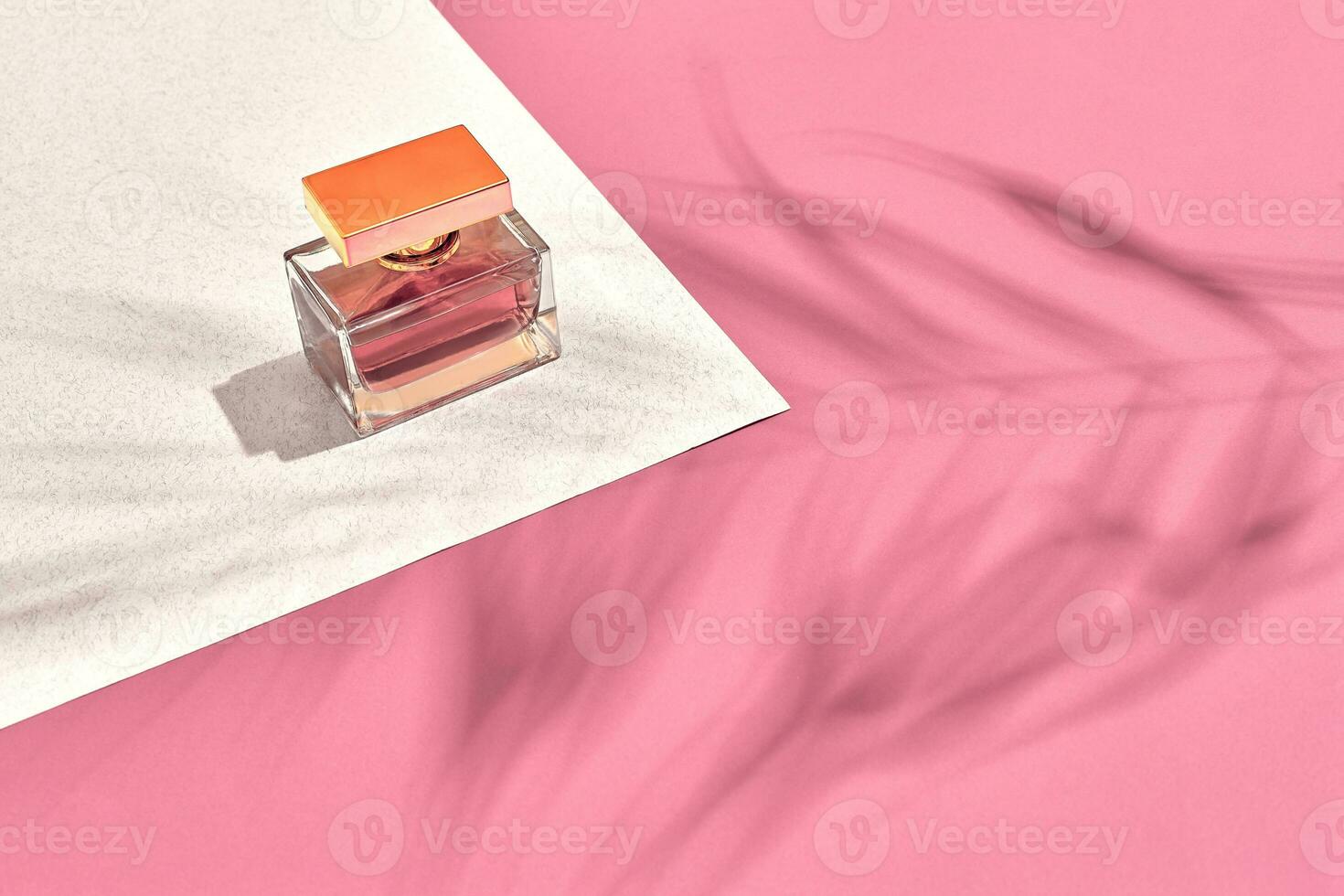 Fashionable Women's Cosmetics and Accessories. Flat Lay. Perfume. Pink and white background. Shadow from a palm leaf photo