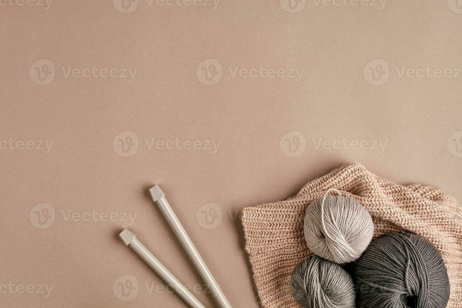Knitted from a gray yarn sweater and thread for knitting closeup. Knitting as a hobby. Accessories for knitting. photo