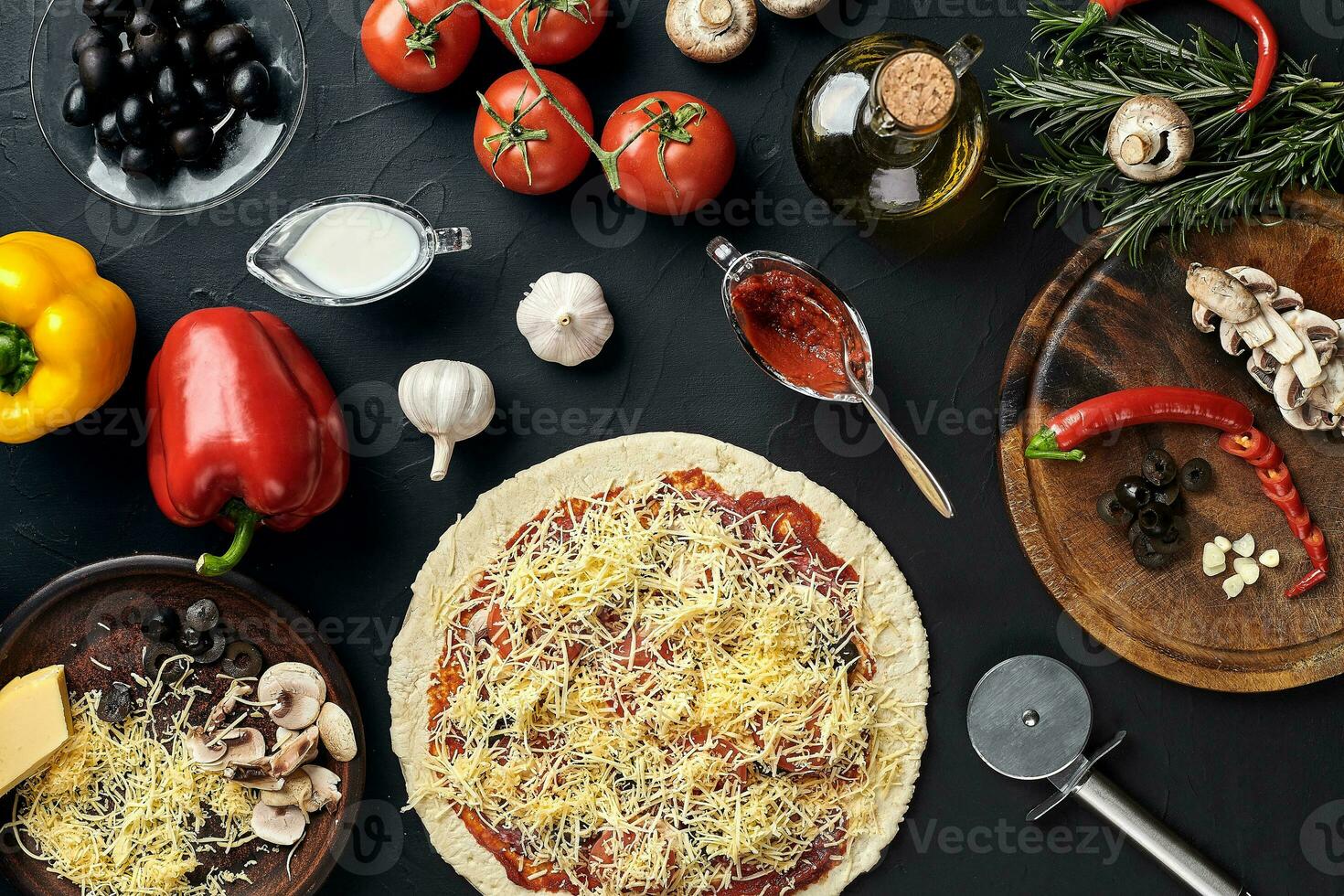 Raw pizza ingredients on black texture table background photo