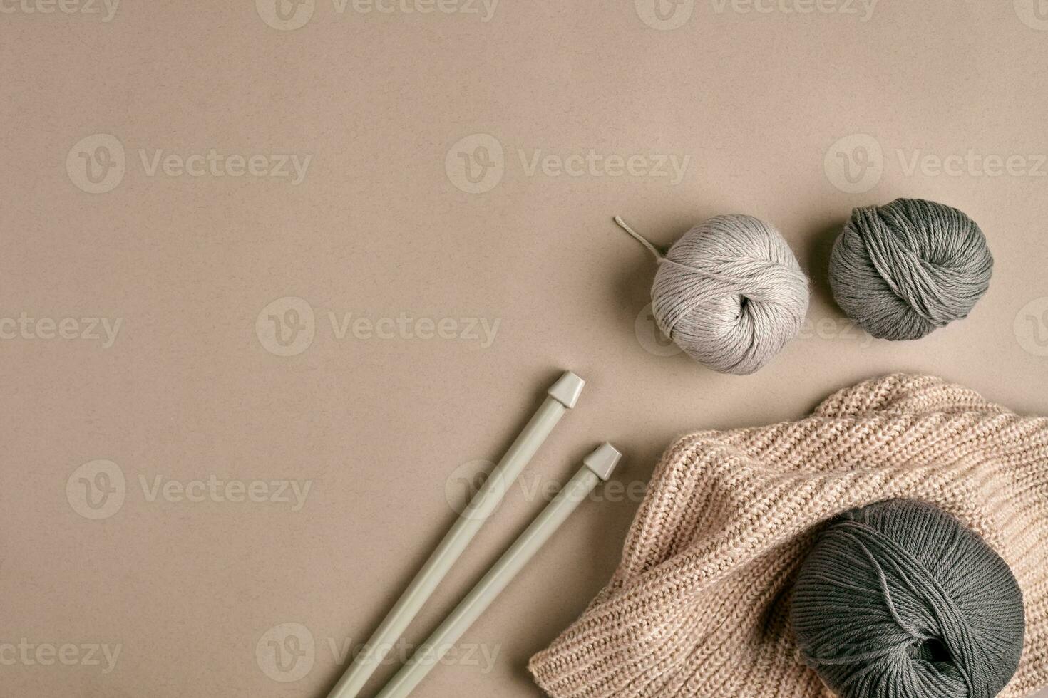 Knitted from a gray yarn sweater and thread for knitting closeup. Knitting as a hobby. Accessories for knitting. photo