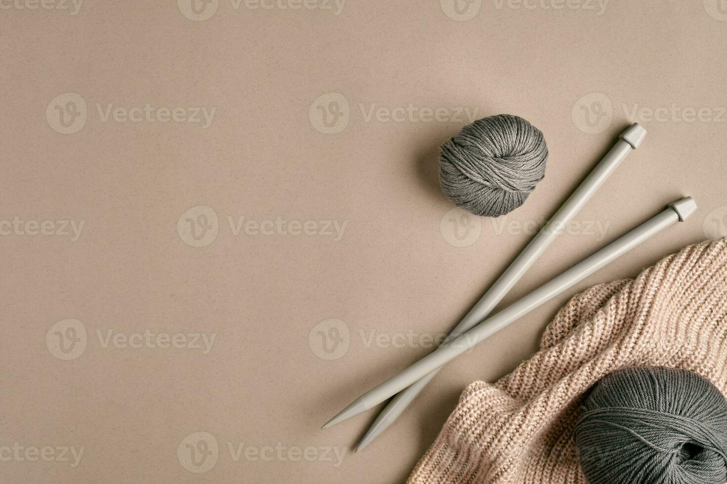 Knitted from a gray yarn sweater and thread for knitting closeup. Knitting as a hobby. Accessories for knitting. photo