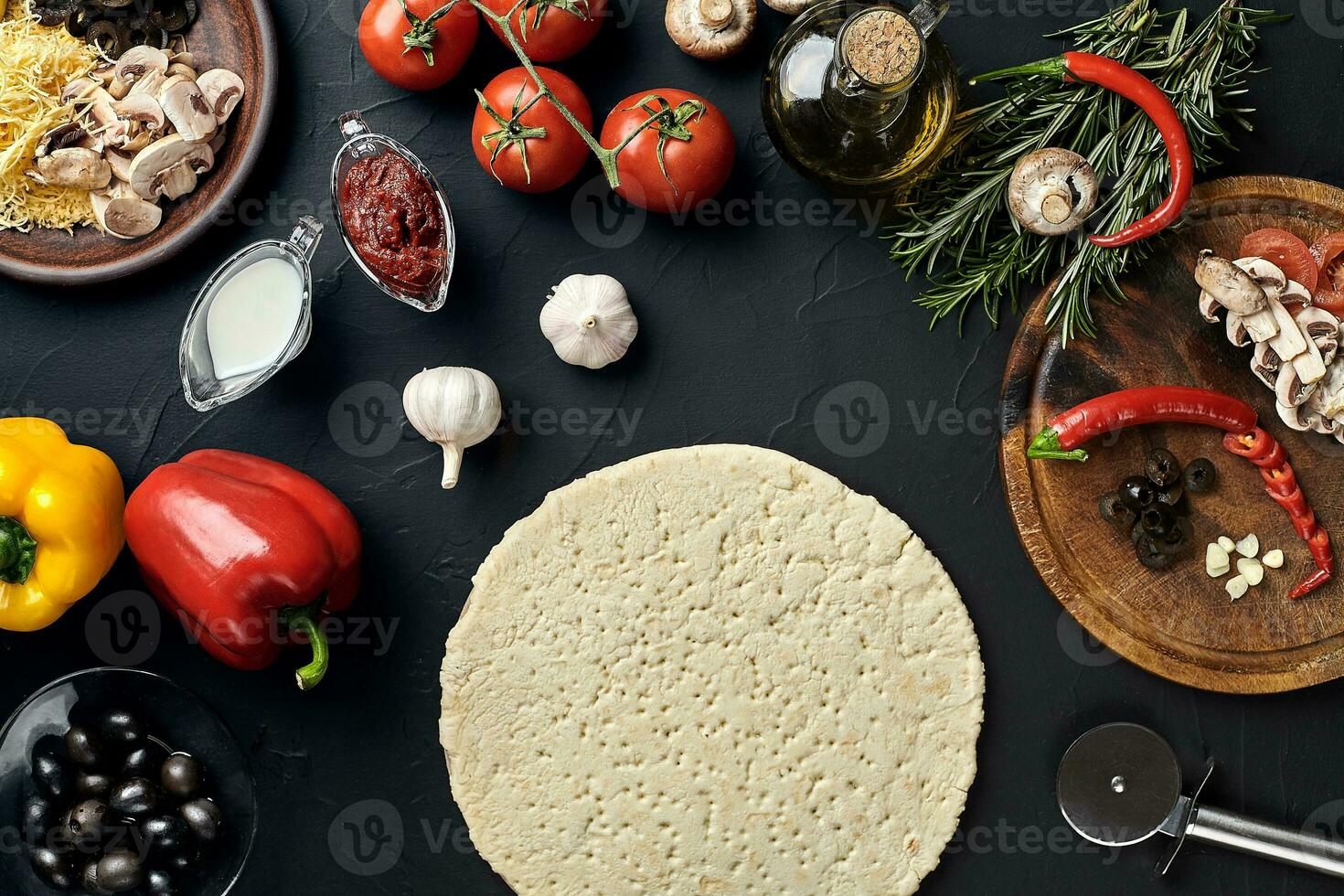 Raw pizza ingredients on black texture table background photo