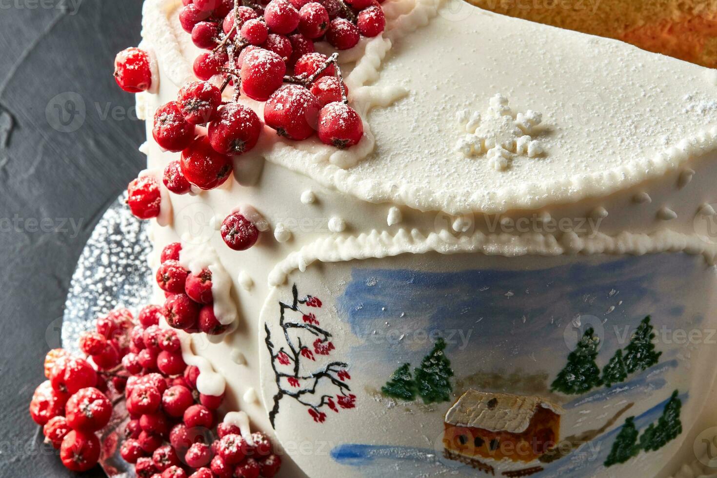 Winter cake covered with white icing, with painted house in the forest, trees and red rowan. photo