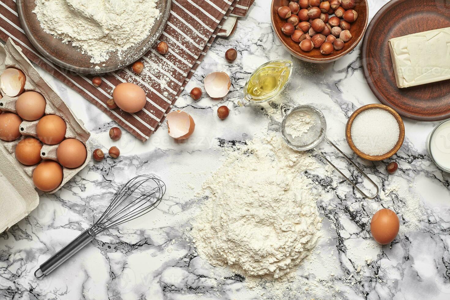 Close-up shot. Top view of a baking ingredients and kitchenware on the marble table background. photo