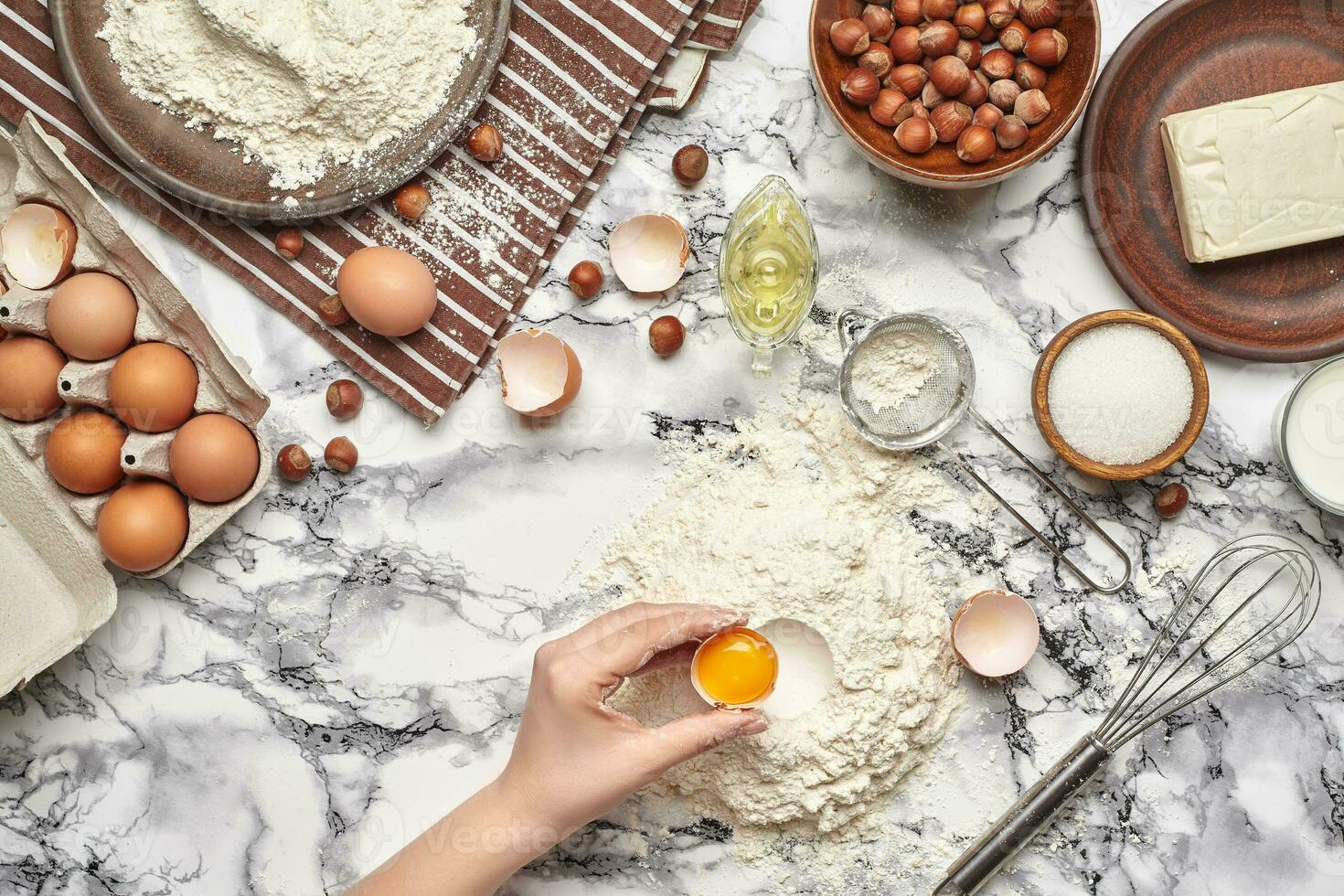 Close-up shot. Top view of a baker cook place, hands are working with a raw dough on the marble table background. photo